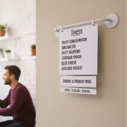 Menu board with burger options and a man sitting in the background