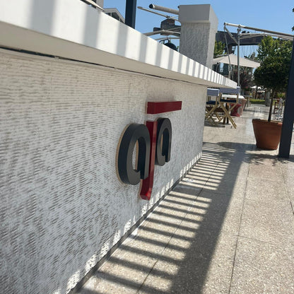 Logo on a building wall with a clear blue sky