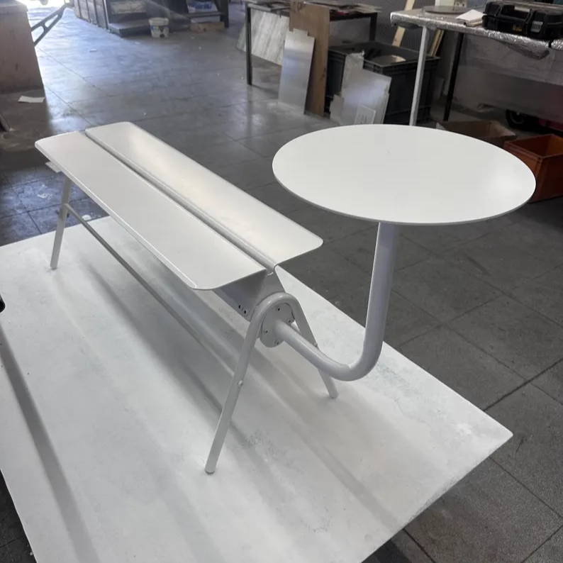 White table and bench set on a tiled floor with a store interior in the background