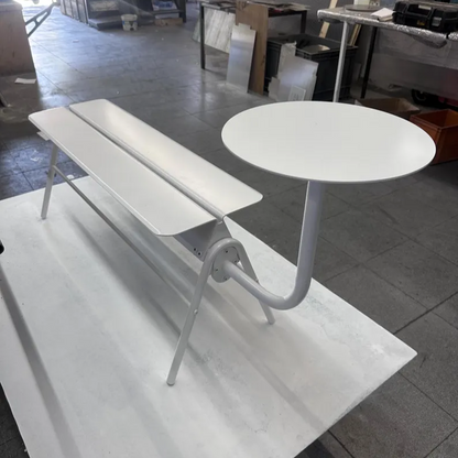 White table and bench set on a tiled floor with a store interior in the background