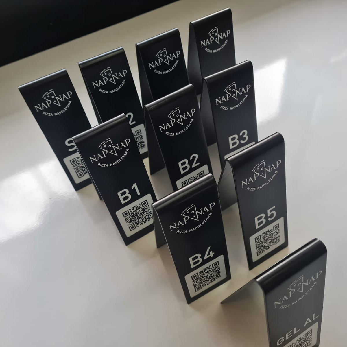 Set of black cards with QR codes and 'Nap-Nap' branding on a white surface.