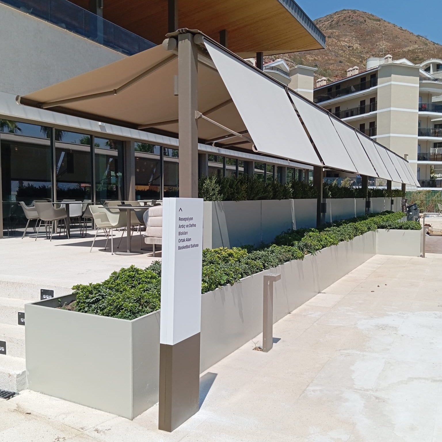 Outdoor seating area with large umbrellas and a mountain in the background