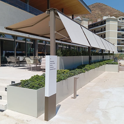 Outdoor seating area with large umbrellas and a mountain in the background