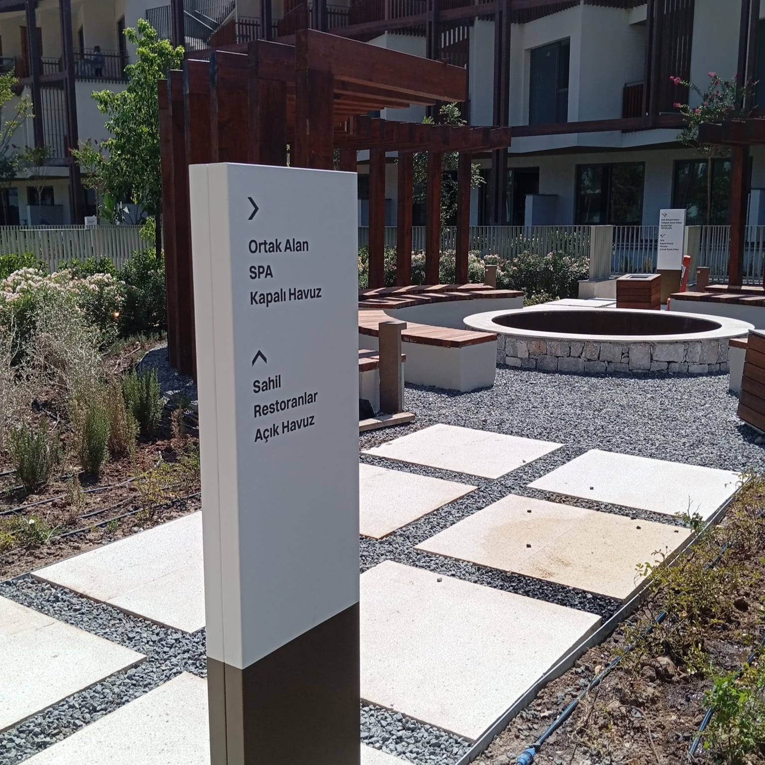 Directional signpost in a courtyard with buildings in the background