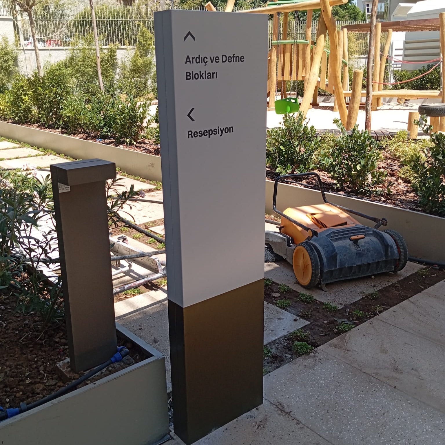 Tall directional signpost with text in an outdoor setting