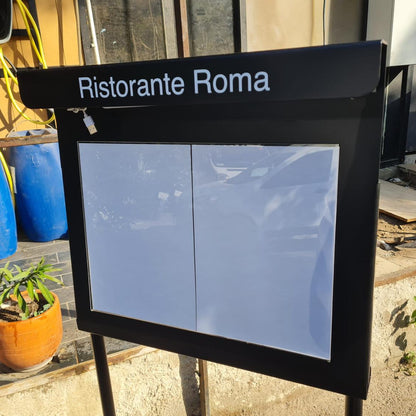 Outdoor sign for Ristorante Roma with potted plants and a building in the background