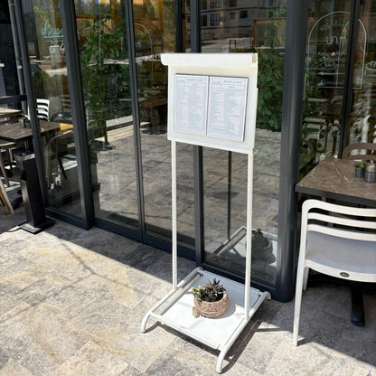 Outdoor seating area with a menu board in front of a glass door with 'unlab' branding.