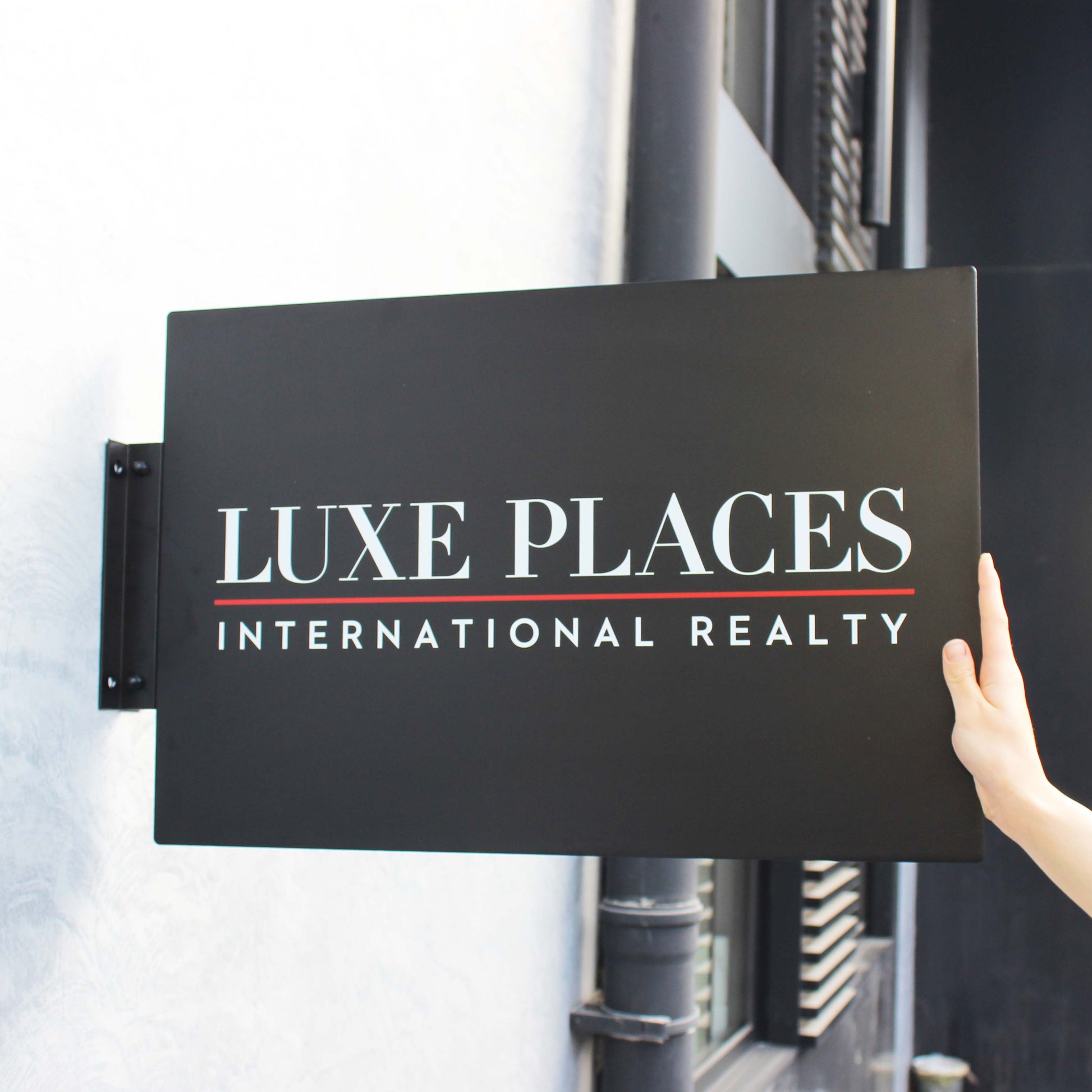 Luxe Places International Realty sign on a building exterior