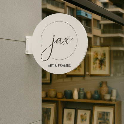 Storefront with 'jax Art & Frames' sign and display of art and frames.