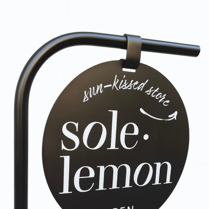 Round sign for 'sole lemon' store with black background and white text.