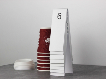"Double-sided personalized table numbers designed for weddings, cafes, and restaurants. Available with QR code printing and customizable in metal or wood to match any business aesthetic."

