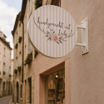Round sign with text and floral design on a building exterior