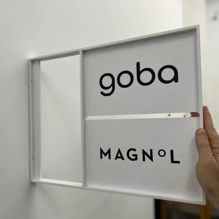 Goba Magnól product held by a hand against a white wall