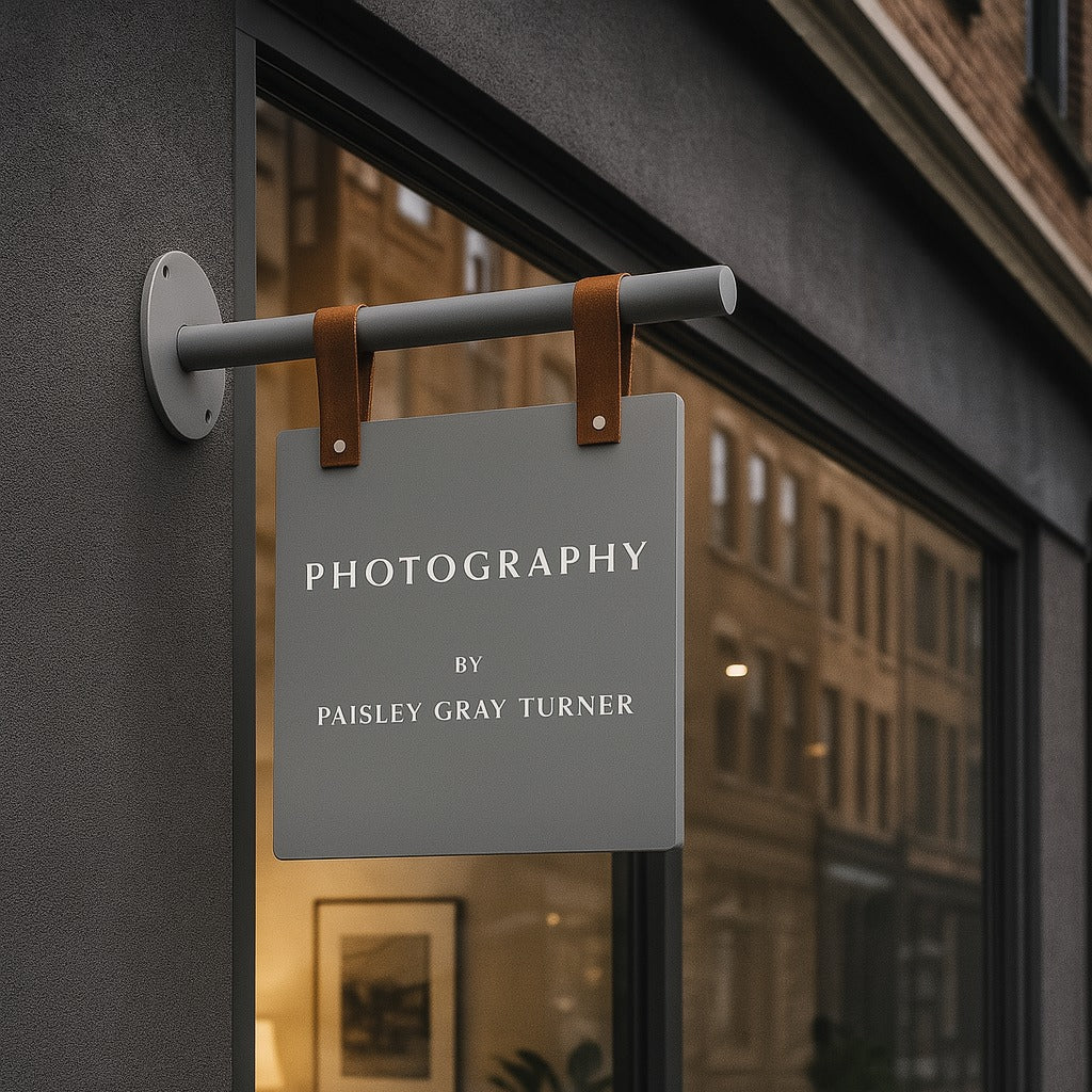 Sign on a door with 'Photography by Paisley Gray Turner' text, reflecting an interior setting.
