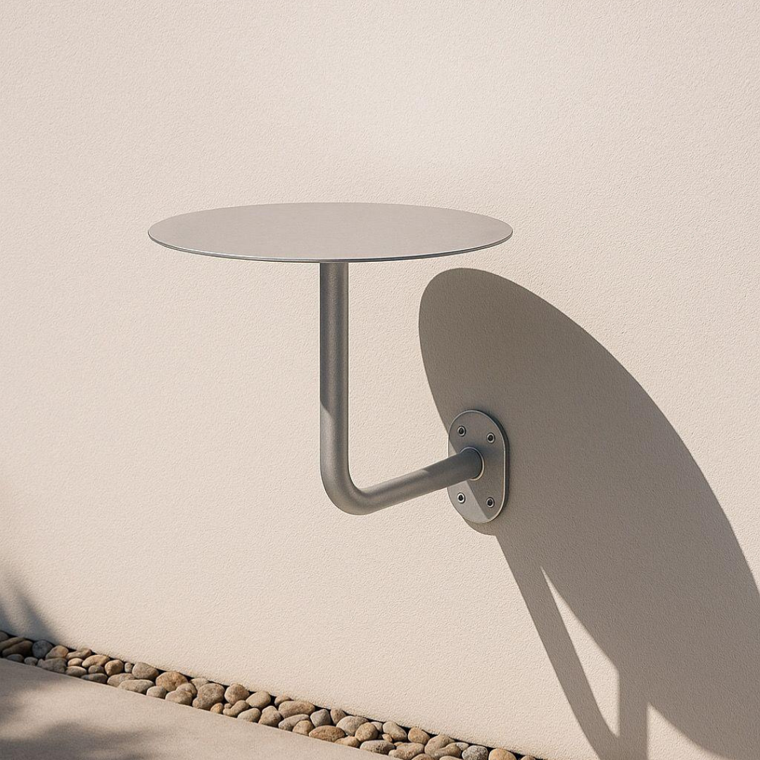 Wall-mounted round metal table with a minimal design against a light background