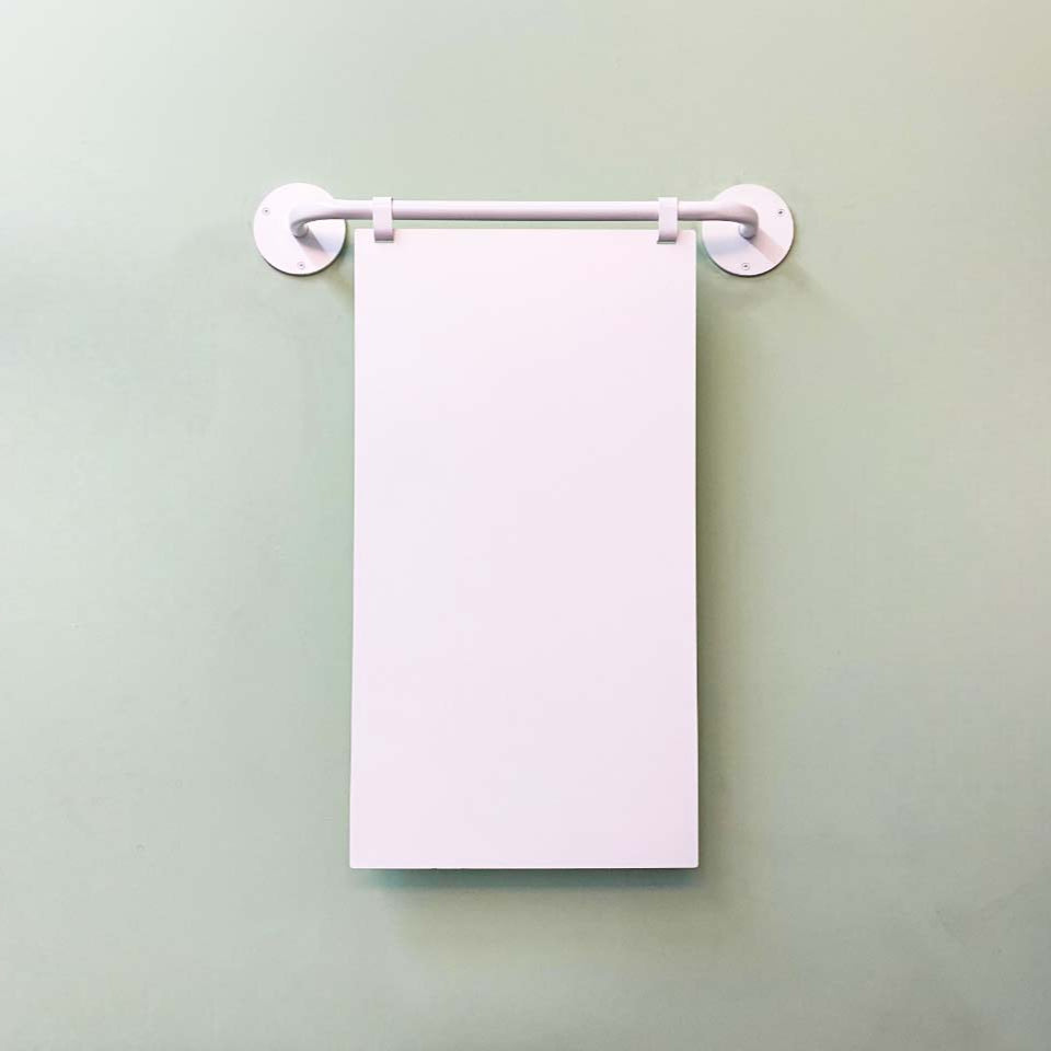 A wall-mounted magnetic menu board displaying a food menu with prices written in black on a purple background.