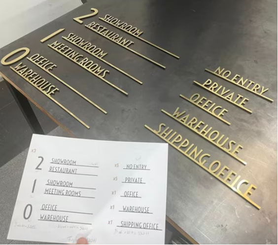 Gold 'WAREHOUSE' sign held by a hand against a blurred background