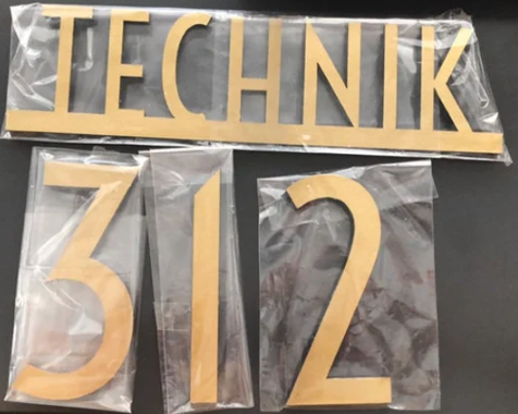 Gold 'TECHNIK' and number '312' on clear plastic packaging against a dark background
