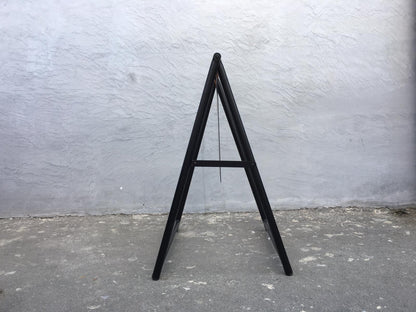 Side view of the unprinted black A-frame sign showing the folding frame and support bar