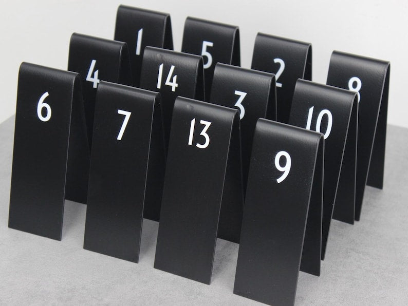 Black stackable metal table numbers arranged as a set
